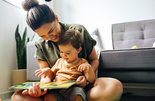 Mother reading with her young child at home